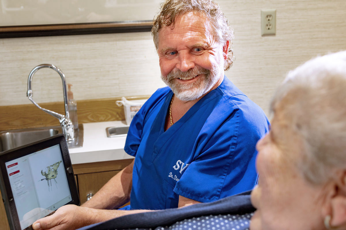 Dr. Steven Saunders Giving A Consultation To A Dental Implant Patient